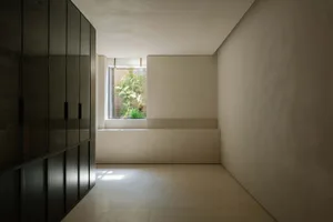 A minimalist interior designed with concrete walls and floor, featuring natural lighting.