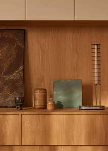 Decorative wooden shelf with various objects on a wooden backdrop and brown wall.