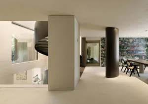 Modern residential dining room with concrete elements and a large dining table.
