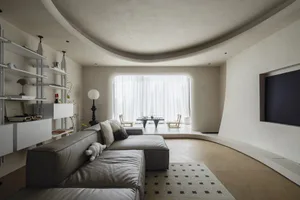A modern living room with minimalist furniture and concrete walls.