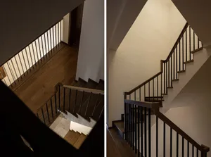 Modern interior design featuring a staircase with light walnut stair treads and stainless steel rails, illuminated by natural