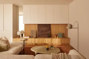A minimalist living room featuring wood, leather, glass, and metal elements.