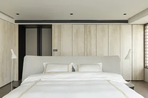 Modern bedroom with light wood texture walls and a neatly made bed.