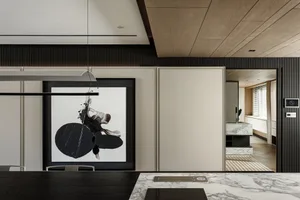A modern dining area with marble countertops, featuring a large abstract painting on the wall.