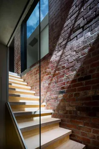 Modern staircase with wooden steps and brick walls