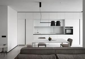 A modern, minimalist kitchen with white cabinets and black accents.
