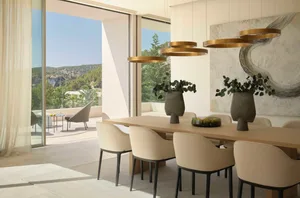 Modern dining room featuring marble and wooden elements, with gold pendant lights and a view of the outdoors.