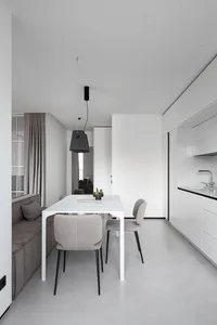 A modern dining room with white furniture and minimalist design.