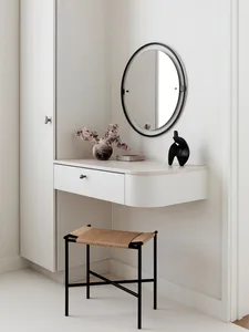 A modern floating vanity station with a marble countertop and a wooden cabinet, featuring a black-framed oval mirror and a bl