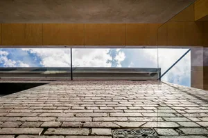 Concrete building with large glass windows on a sunny day.