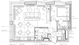 A detailed technical drawing of a modern living room with dimensions provided, featuring an L-shaped sofa, coffee table, and 