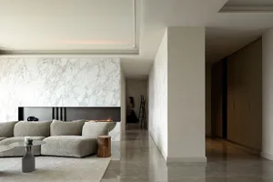 Contemporary living room featuring marble walls and concrete flooring.