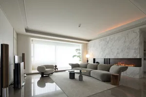 Minimalist living room with marble accent wall and furniture.