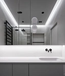 A modern minimalist white bathroom with sleek lines and a neutral color palette.