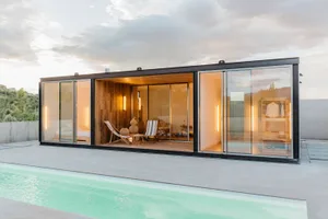 A modern residential exterior featuring glass and concrete materials.