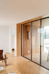 Modern residential interior featuring glass doors and wooden floors