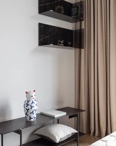 A minimalist bedroom featuring glass and marble decor elements.