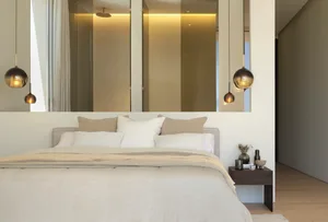Modern bedroom with cream-colored bedding and a minimalist design.