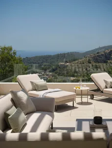 Outdoor lounge area featuring modern, comfortable seating with fabric cushions and a scenic backdrop.