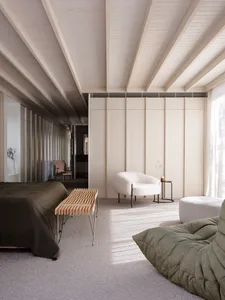 Minimalist bedroom featuring a wooden floor and minimalist furniture.