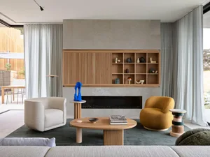 A modern living room with a fireplace, two armchairs, and a coffee table.