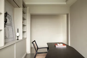 A minimalist residential lobby featuring concrete materials and a sleek, contemporary design.