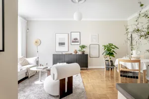 Minimalist living room featuring a white sofa, abstract art, and a sleek sideboard.