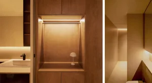 Modern bathroom with lighted storage shelf in wooden wall