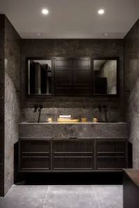 A modern bathroom with black marble tiles and a double vanity sink.