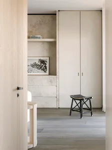 A modern bedroom featuring concrete walls and a minimalist design.