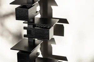 A modern, black, wooden floating shelf system.