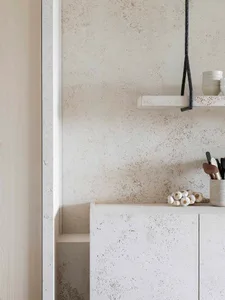 Modern kitchen with minimalist design featuring textured concrete cabinets and countertops.