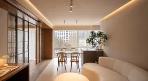 A modern living and dining room with neutral tones and minimalist design.