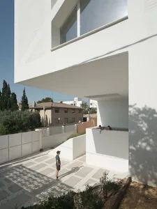 A modern, white-rendered residential architecture with an open patio and a swimming pool.