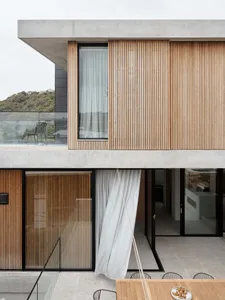 Modern exterior with wooden and concrete materials and large windows.
