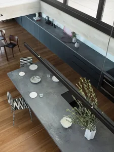 A modern, industrial kitchen with concrete countertops and minimalist decor.