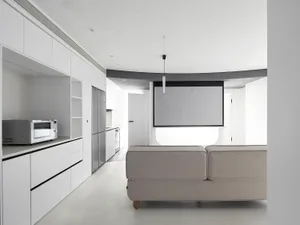 A modern minimalist living room and kitchen concept featuring white materials.