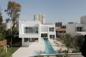 Modern residential architecture featuring glass, concrete, and white materials.