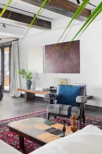 A living room featuring industrial design elements such as wood, ceramic tiles, and fabric.