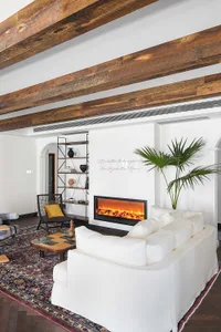 Industrially designed living room featuring wooden beams, concrete floor, and metal accents.