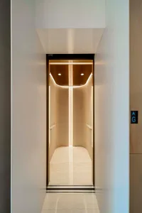 Modern, luxurious elevator interior with warm lighting and minimalist design.