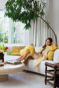 A stylish living room featuring a white sofa adorned with yellow decorative elements.