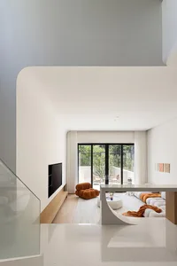 A minimalist living room with concrete and wood elements, featuring a large glass window, comfortable seating, and modern dec