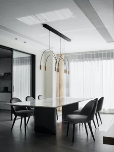 Modern dining room with marble table and black furniture.