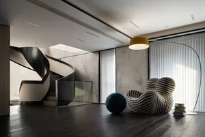 A modern interior with a staircase featuring marble and glass, and a striped armchair.