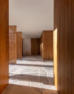 Modern interior design featuring a wooden floor with geometric patterns and natural light.