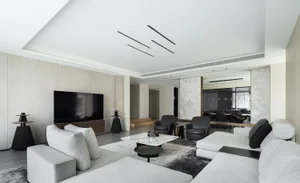 A modern living room featuring marble, cement, and upholstered furniture.