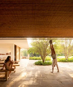 A modern living space featuring a stone floor, wooden ceiling, and natural lighting.