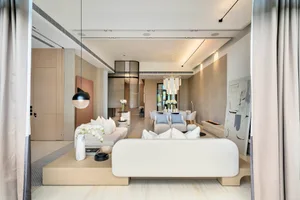 A minimalist living and dining room with marble and wood elements.