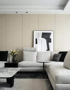 Contemporary, minimalist living room featuring a large, comfortable sofa upholstered in fabric and adorned with black and gra